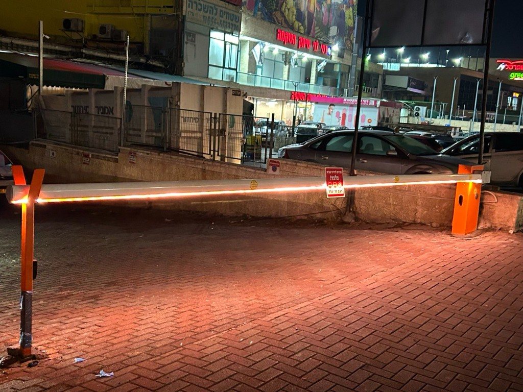 מחסום חניה חשמלי עם פס LED בכניסת חניון בלילה | שפירא מערכות