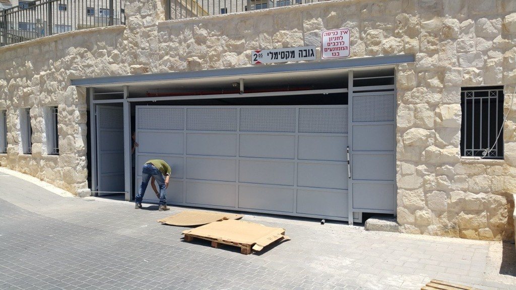 שער נגרר לחניון עם פאנלים מחוררים ודלת הולכי רגל | שפירא מערכות