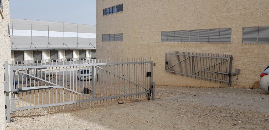 שער כנף כפול תעשייתי עם מנועי זרוע בכניסת מתחם | שפירא מערכות